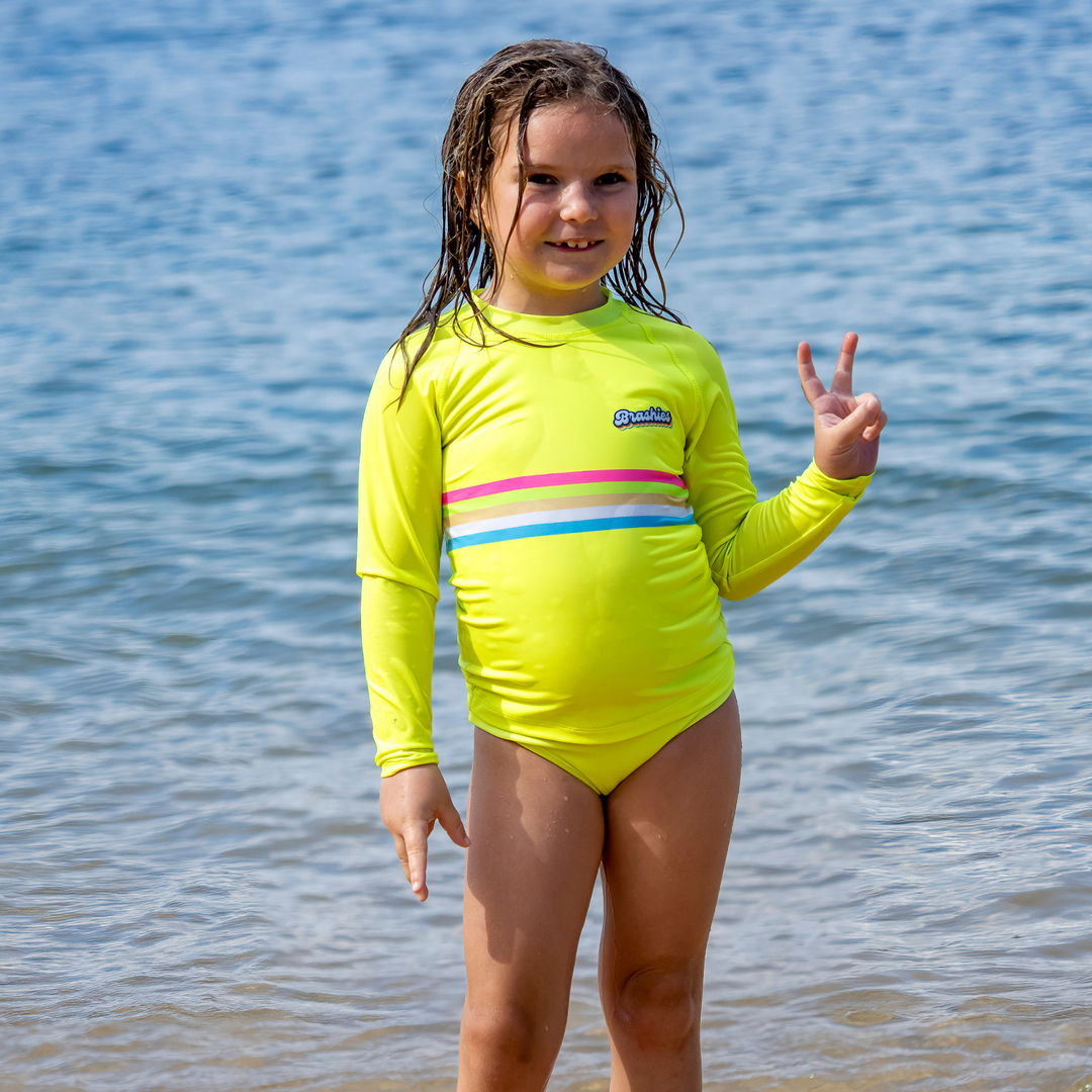 Child wearing Rainbow Beach long sleeve rashie with bold colours