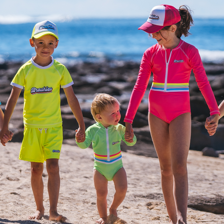 Toddler in Camp Cove long sleeve pink swimsuit at the beach