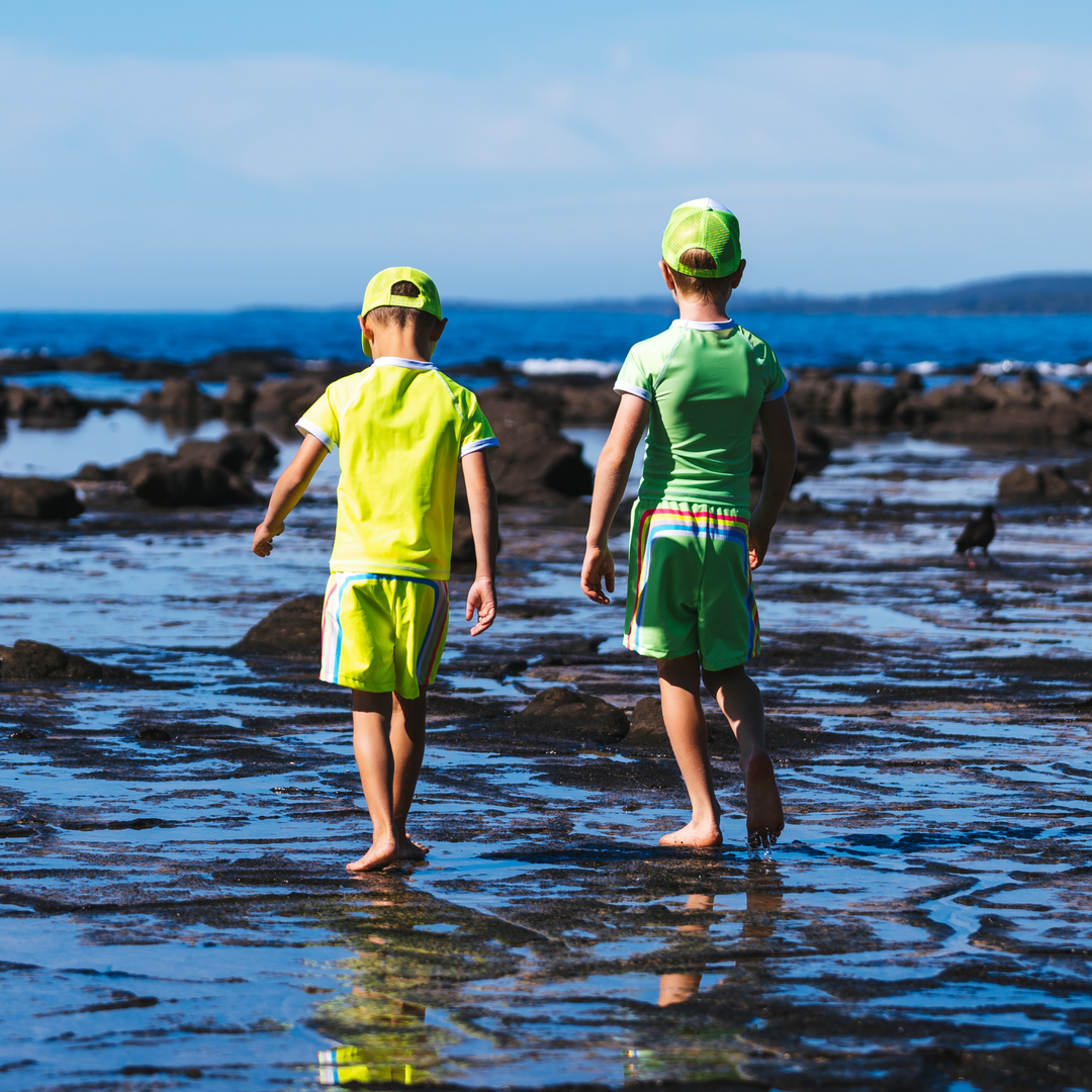 Boy running in Balmoral boardshorts on sand